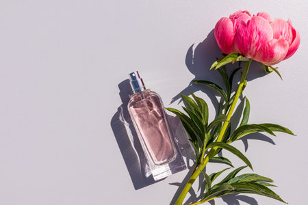 A chic bottle of cosmetic spray, perfume, eau de parfum on a light background with delicate live...