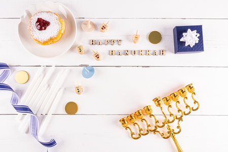 A festive backdrop with symbols and traditional treats for the holiday of Hanukkah. top view. flat lay. wooden letters, the text of congratulationsの写真素材