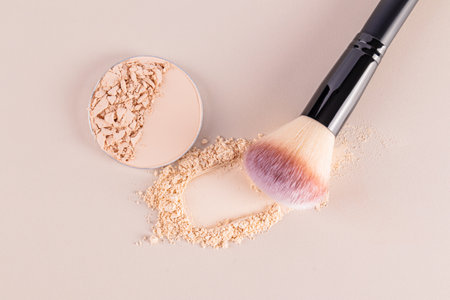 A sample of a round block of compact powder in a brown tone and a chic brush for applying makeup. loose powder sample. top view. layout for design.の写真素材
