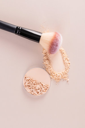 Natural tone powder pieces and make up brush on a vertical beige background. layout for design. template. A copy space. Care and beauty concept.の写真素材