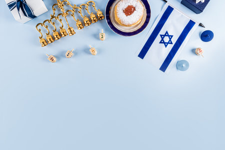 Traditional treats and symbols of the Jewish holiday of Hanukkah in blue white color on a blue background. top view. top border. space for your textの写真素材