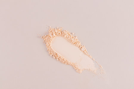 The cosmetic texture of a compact, loose powder with a natural tone. sample, a smear of powder. top view. Beige background. A copy space. layoutの写真素材