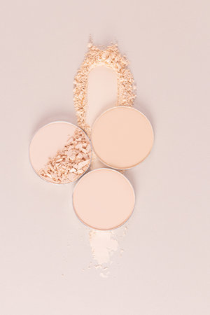 Cosmetic texture of decorative compact powder on a beige vertical background. A few blocks of...