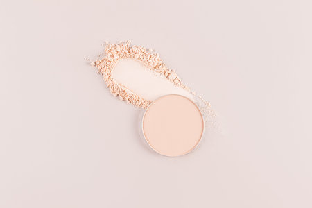Cosmetic texture of decorative compact powder on a beige background. A block of compact powder in a...
