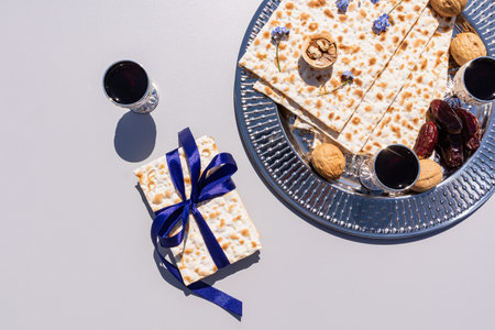 Traditional Passover Eve Celebrations on a silver tray, red wine, slices, a shot of matzah with a blue ribbon. top view. The concept of the holidayの写真素材