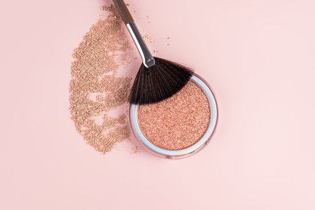 Round cosmetic packaging with a chic highlighter of natural shine. Fan professional makeup brush....