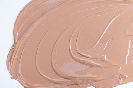 Liquid cosmetic texture of foundation, liquid powder in beige tone. waves of cosmetic texture. Abstract cosmetic background for product advertisingの写真素材