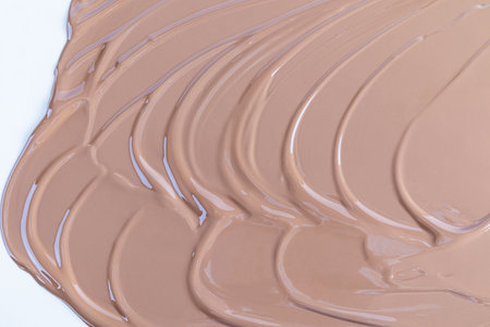 Chic cosmetic background of liquid foundation of coffee tone. Soft beautiful waves of liquid powder. The texture of a makeup makeup. A sample product.の写真素材