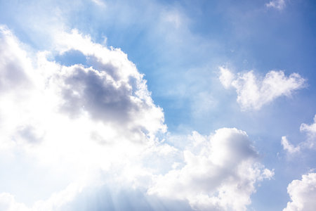 Beautiful cumulus clouds with sunlight. The direct rays of the sun shine through the clouds. Stillness of nature, the atmosphere of the skyの写真素材