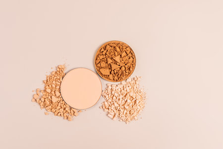 round blocks compact powder of different tones stand on the samples, pieces of broken powder. top view. Beige background. texture samplesの写真素材