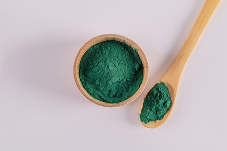 Top view of a wooden bowl and spoon filled with natural spirulina blue algae powder. Organic weight loss product, superfoodの写真素材