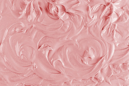 Delicate swirl curls of the texture of creamy fruit cream. pink texture with a pattern. A sample of...