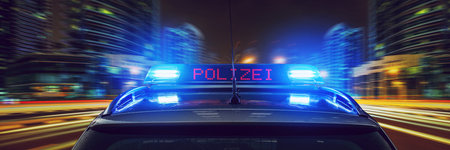 Police car with blue flashing lights on the background of the night city