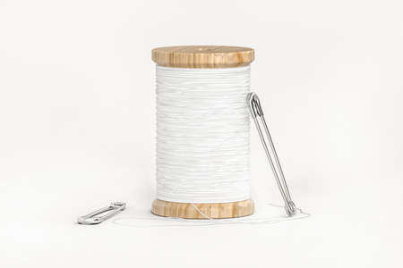 Spool of white thread and two safety pins isolated on white - 3d renderの写真素材