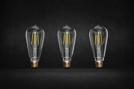 Concept of three light bulbs placed on black background in retro style with space for text - 3d illustrationの写真素材