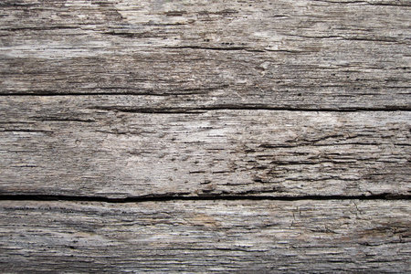 Wood texture - top view and close-up of old fence boards with large unevenness and cracksの写真素材