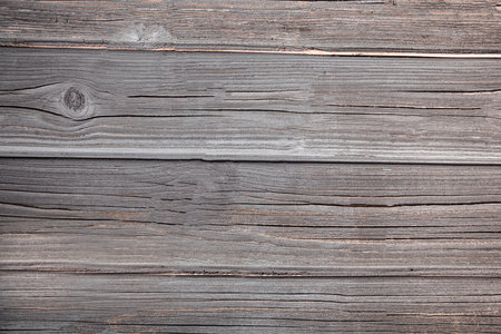 Wood texture - top view and close-up of old fence boards with large unevenness and cracksの写真素材