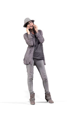 A woman in fashionable clothes stands and talks on the phone - isolated on a white background - 3D Illustrationの写真素材