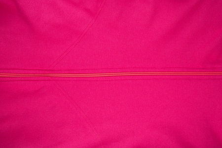 Pink cotton texture - top view and close-up of a fragment of crumpled pink cotton with a zipperの写真素材