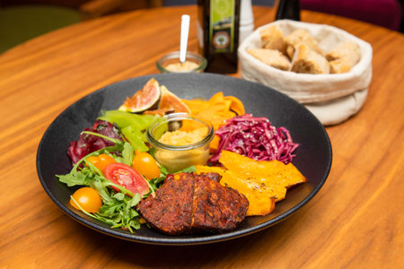 Food photography - Roasted pork meat with potatoes, vegetable salad, fruit and bread in a basket.の写真素材