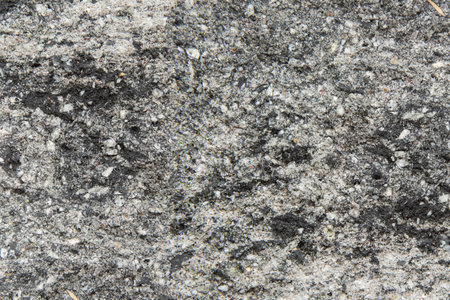 The texture of the stone wall - a close-up of a fragment of a fence made of gray-graphite stone...