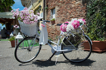 Classic white bike decorated with pink flowersの写真素材
