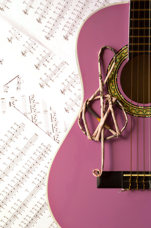 Violet guitar for children with treble clef on music sheets backgroundのeditorial素材