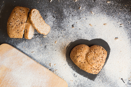 Heart shape of wholemeal bread on blackboard backroundの写真素材