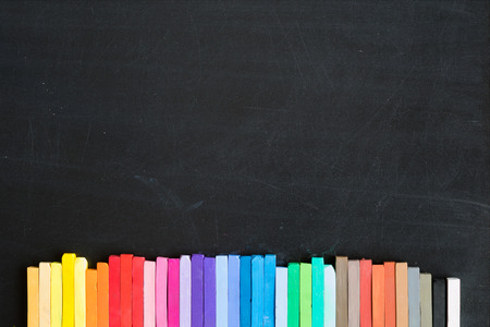 Colorful chalks lined up on blackboard background bannerの写真素材