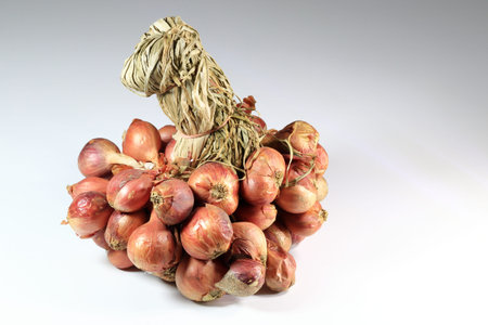 Closeup to a bunch of red shallot onions, Shallot onions in a group isolated on white background, ...