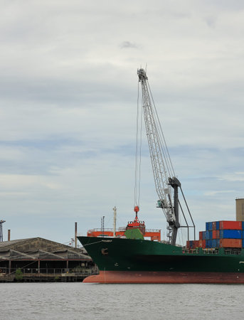 cargo ship or Ocean barge with cranes at international port, with CBD background Logistics and...
