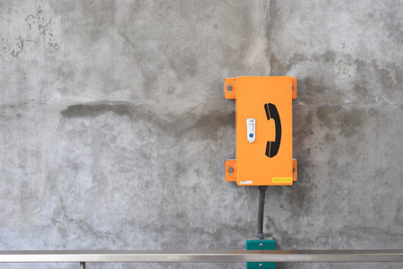 The yellow emergency phone box beside Pedestrian pathway in bus or train station, Electronic Devices...