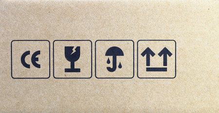 packaging symbols: CE mark symbol, fragile or handling with care symbol, keep dry symbol and side up symbol. Collection of symbols for cardboard packaging.の写真素材