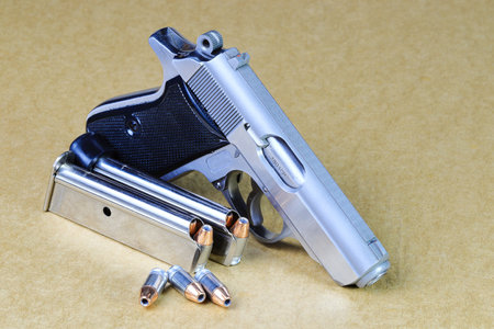 The compact Semi automatic pistol, stainless steel PPKs pistol with spare magazines right side view, Ready for use, lying isolated on white background.の写真素材