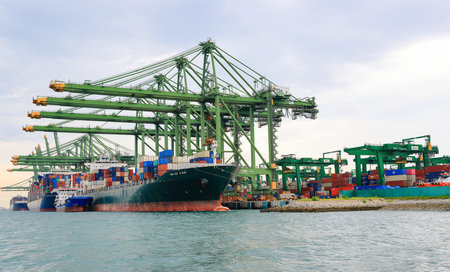 Cargo transportation and activity at Singapore's shipping container terminal as Asia modernizes its port and worldwide trade.のeditorial素材