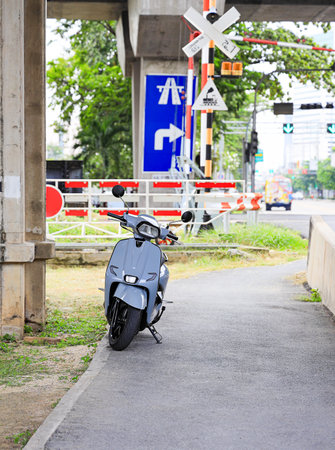 Modern scooter parked on the side of small road.の写真素材