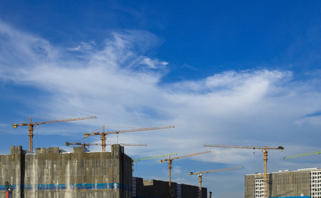 construction tower crane work with construction worker on top of building, used in construction site with blue sky.の写真素材