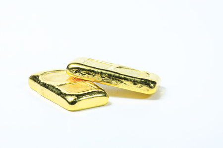 A stack of real shiny gold bars or gold ingots isolated on white background.