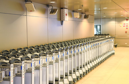 Row of airport trolleys get ready to serve passengers at Airport terminal.の写真素材