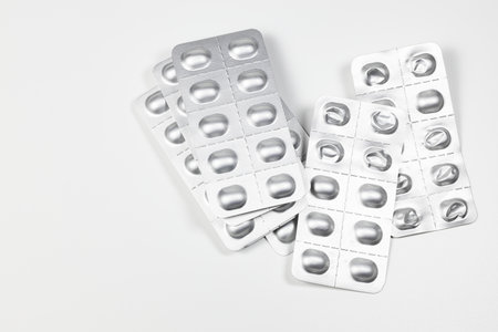 Some used pill blister packs, Medical drugs and pills in silver shiny package isolated on white background.の写真素材