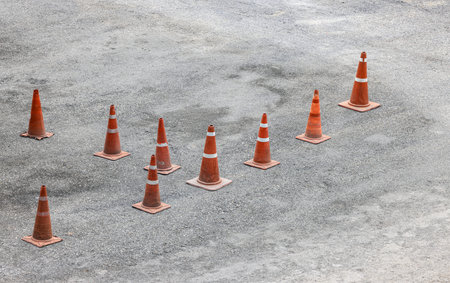 row of orange fluorescent, reflex traffic cones on road.