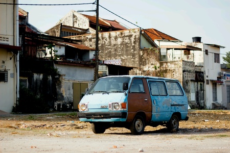 Old van behind buildingの素材