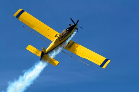 Crop duster at work applying chemicals to fieldの写真素材