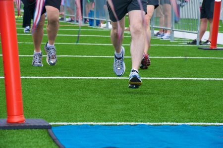 Runners approaching finish line on football fieldの写真素材