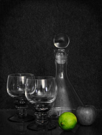 still of a scene with two romanian glasses and a glass carafe surrounded with some fruit, an apple and a lemon. The lemon has its original color when the picture was taken.の写真素材