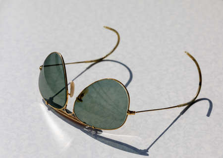 Sunglasses resting on the tabletop in the sunの写真素材