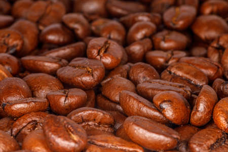Close-up of roasted coffee beans spread out on a table topの写真素材