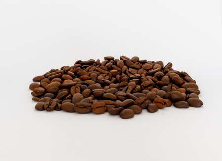 Bunch of roasted coffe beans against a white backgroundの写真素材