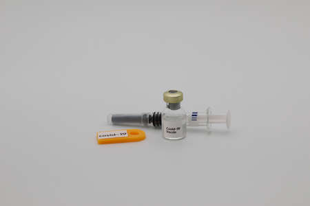 Covid-19 vaccine in vial and accmpanied with syringe against a white background.の写真素材