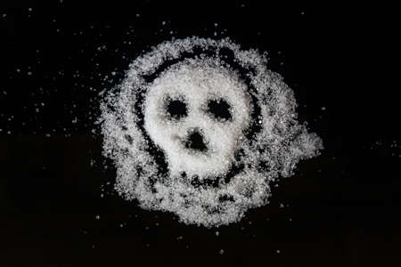 Concept. Sugar poured on black glass in the shape of a skullの写真素材